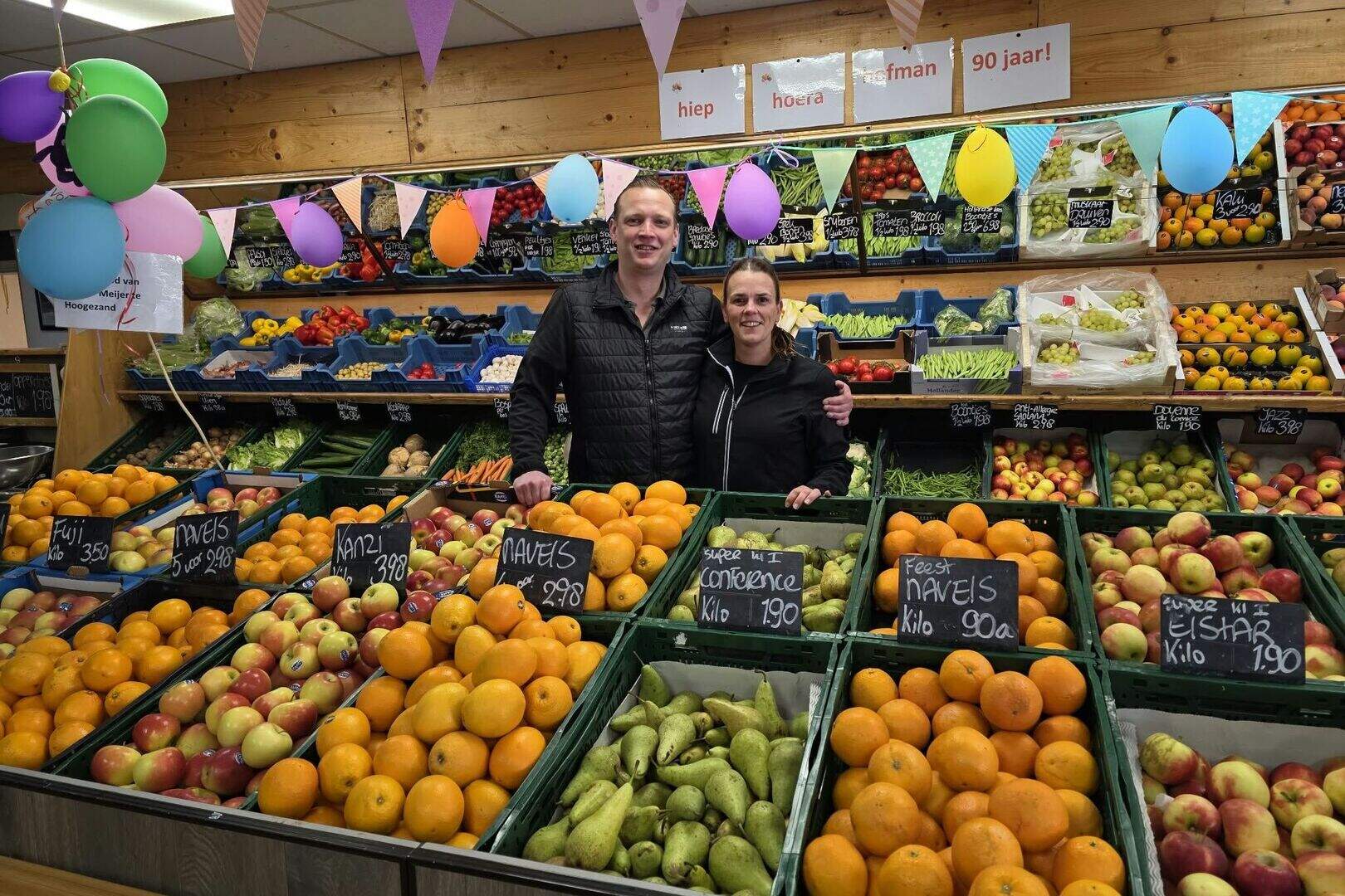 Ronald Nijhoving en Lizzy Hofman in hun winkel, versierd voor het 90-jarig jubileum